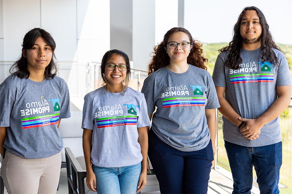 Four smiling students wearing grey t-shirts with the Alamo Promise logo